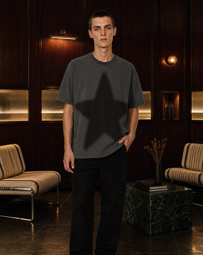 Model wearing the Washed Star Tee in a dark wood-panelled lounge - editorial